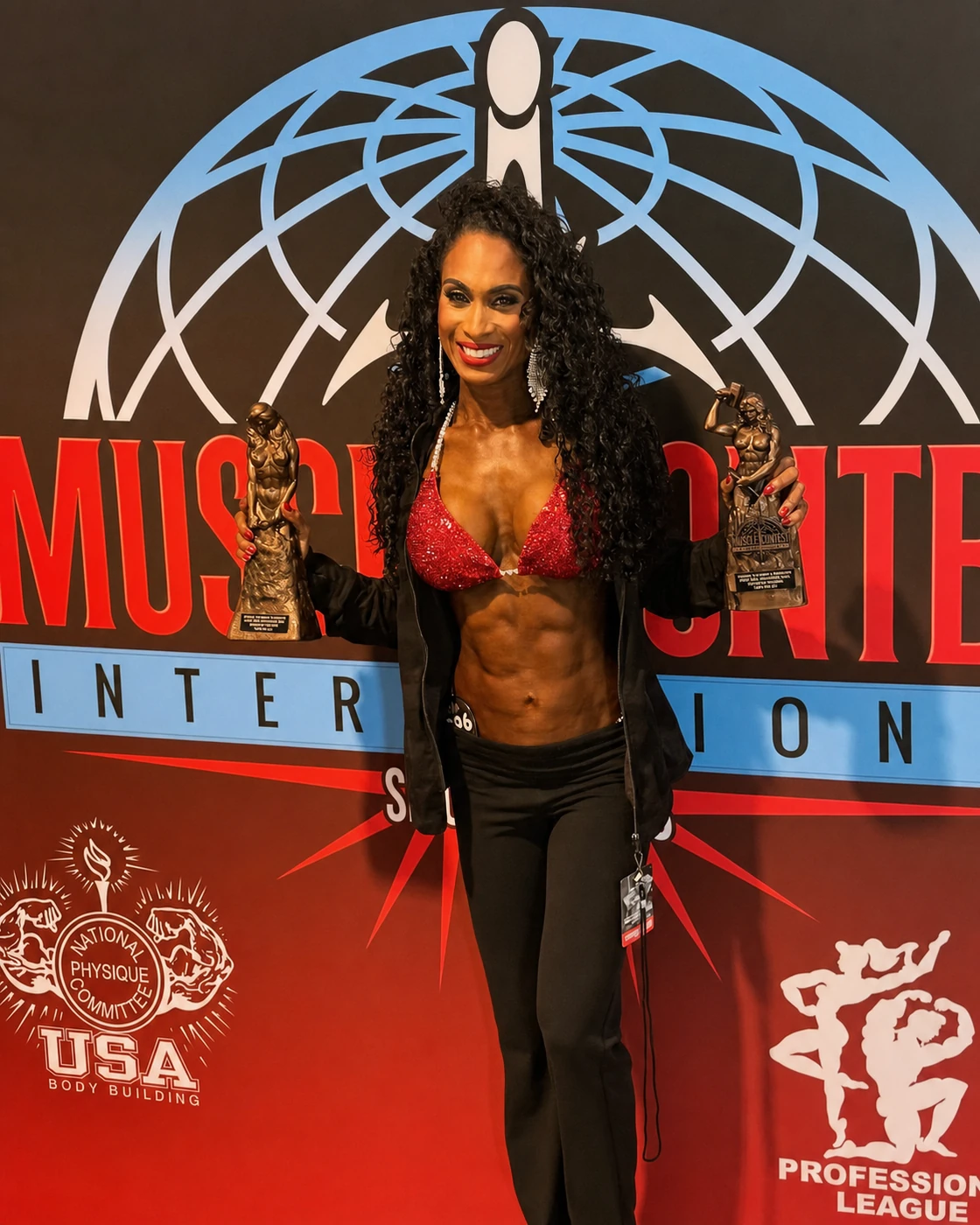 Posing client holding two competition trophies