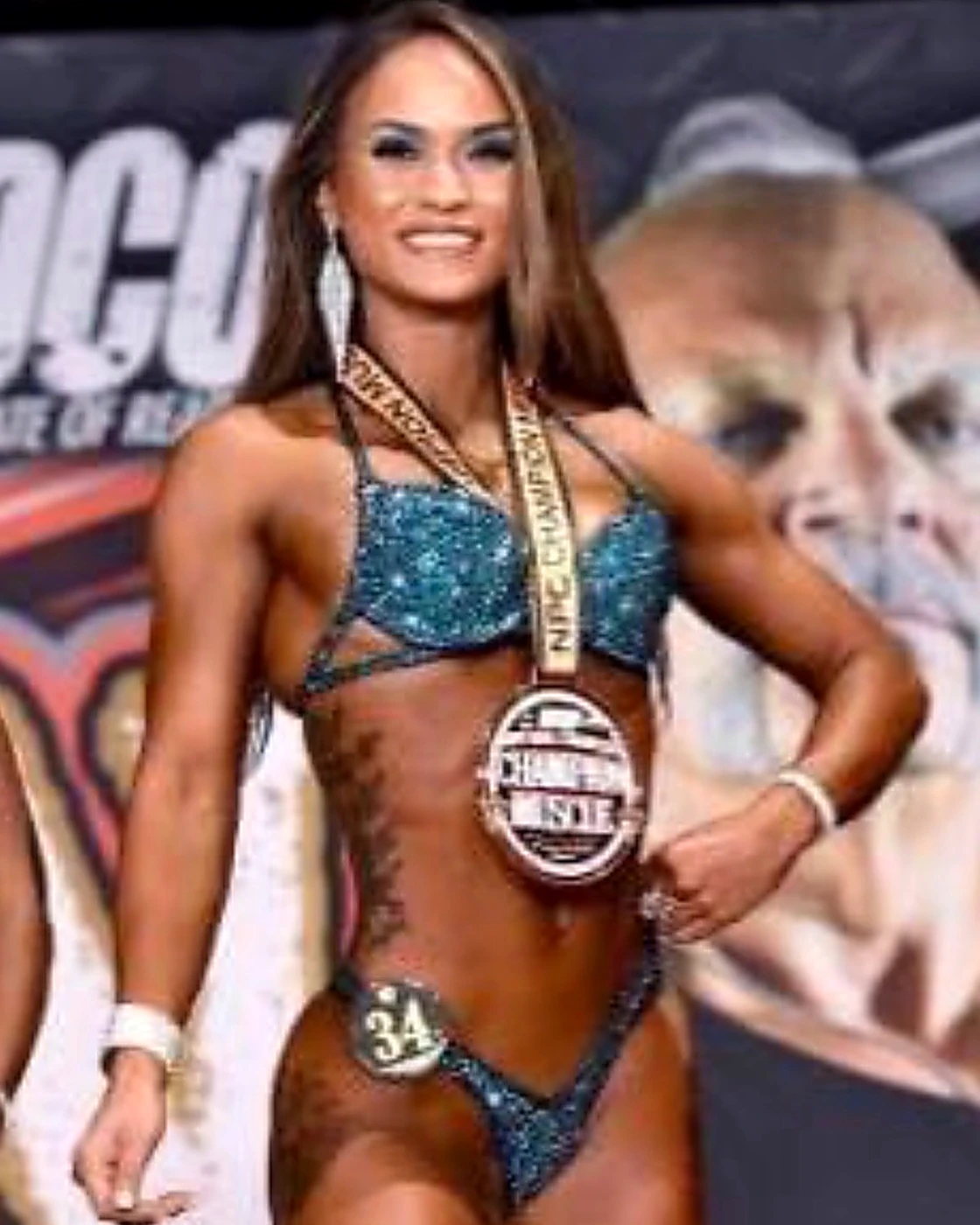 Posing client number 34 on a bodybuilding competition stage